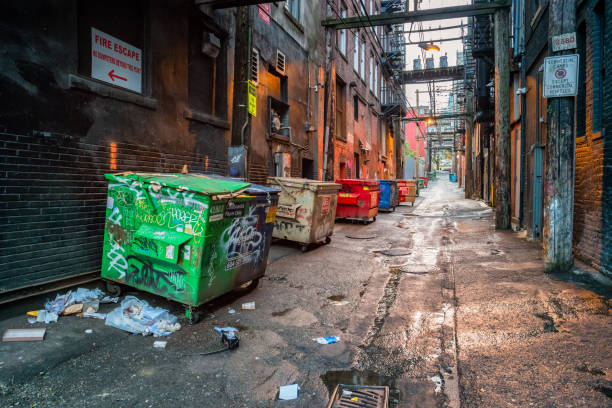 Back alley with garbage dumpsters in downtown Vancouver, British Columbia, Canada in the evening.