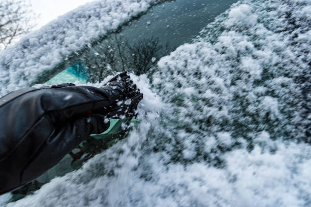 istock Gloved hand with scrapper removing snow from car windows - motion blur 1068106718