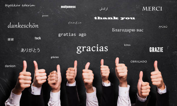 多くの言語で「ありがとう」という言葉を持つ黒板の前に多くの親指 - gratitude ストックフォトと画像