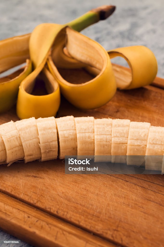 Ripe banana without peel, cut into round slices on a wooden background. Backgrounds Stock Photo