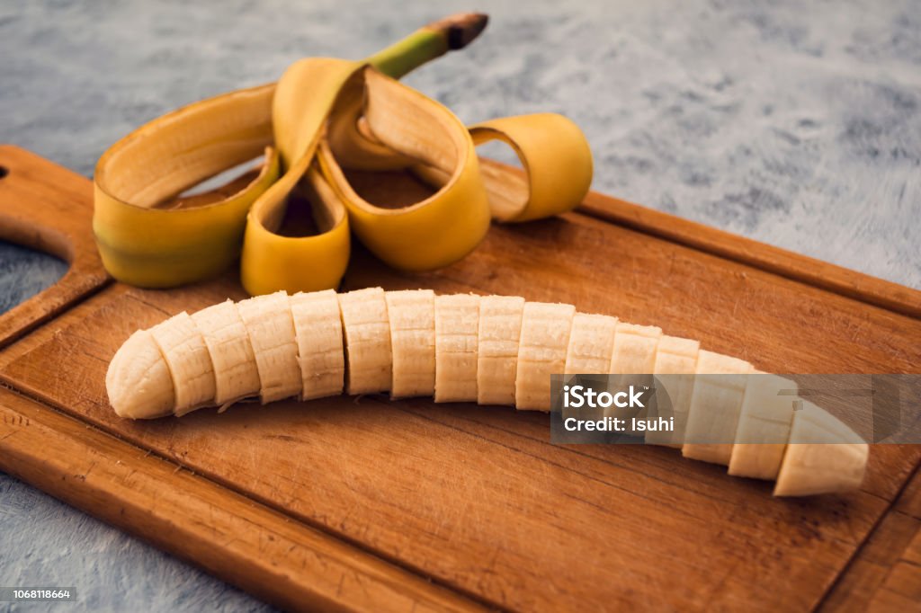 Ripe banana, white middle cut into transverse slices, wooden background, cut peel beautifully laid on the Board. Banana Stock Photo