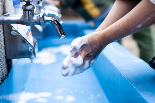 Children washing their hands with a father along with their father