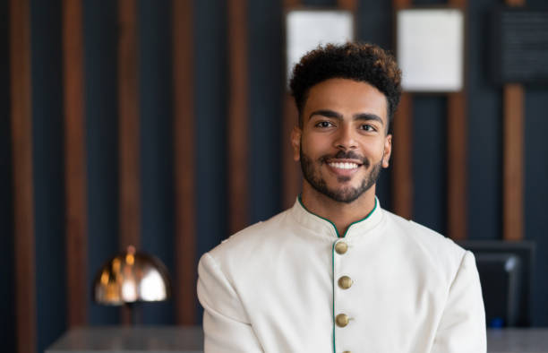 Portrait of black friendly bellhop working at hotel looking at camera very happy Portrait of black friendly bellhop working at hotel looking at camera very happy and smiling bellhop stock pictures, royalty-free photos & images