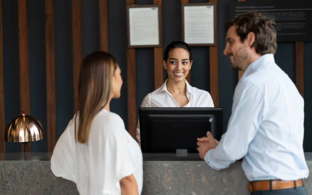 istock Latin american couple checking in at hotel and friendly receptionist doing the process while smiling 1068158452