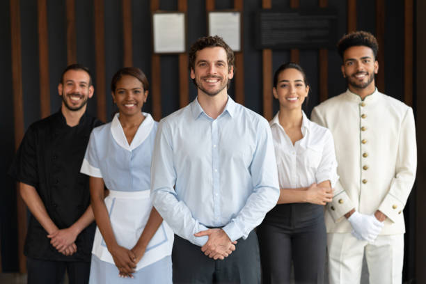 istock Multi ethnic group of workers at a luxury hotel all looking at camera smiling 1068158470