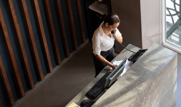 latin american hotel receptionist taking a phonecall - hotel reception imagens e fotografias de stock