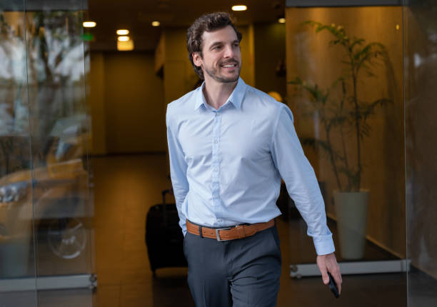 istock Cheerful businessman leaving hotel looking away smiling 1068158630