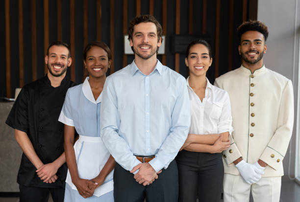 istock Confident multi ethnic group of employees at a hotel reception all looking at camera smiling 1068158766