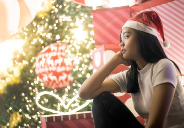 istock asian lady siting near christmas tree and night light 1068161044