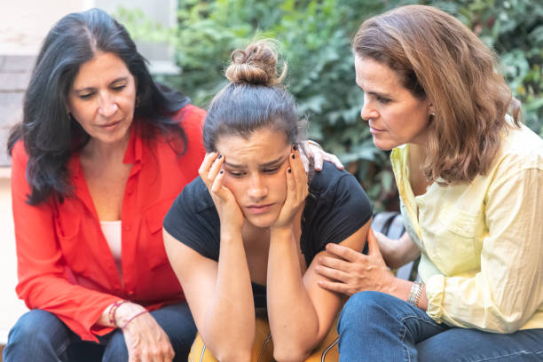 Mature women consoling their daughter Mature  multiethnic lesbian couple consoling their daughter because she became pregnant sad gay stock pictures, royalty-free photos & images