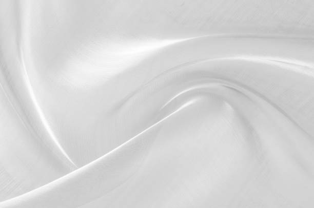 istock Background texture, pattern. The fabric is white. White silk fabric background elegant and delicate. Bright satin fabric, folded for use as a background. Upper type of fabric Textile surface. 1068170228