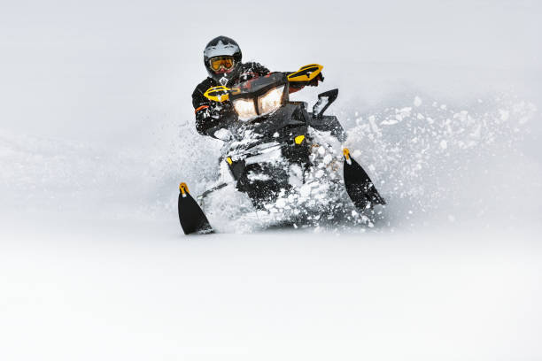 In deep snowdrift snowmobile rider make fast turn