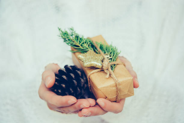 istock Woman's hands hold christmas or new year gift box. 1068215378