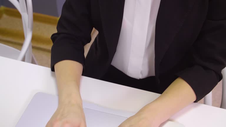 Female hands typing on keyboard notebook at table in business office top view