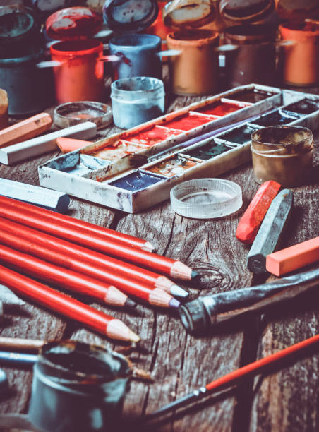 istock Tools for the artist. Inspiration to create. Objects for drawing. Paint, crayons, pencils on a wooden table 1068222724