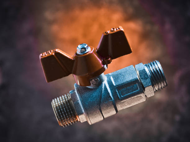 istock Ball valve on the background of a concrete wall. Mystical red light. 1068224092