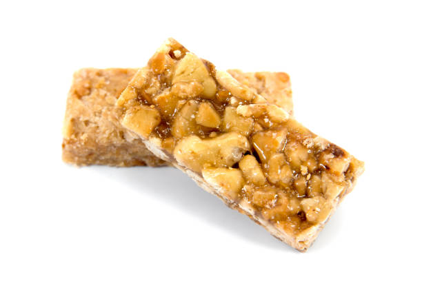 It is two closeup of caramel peanuts bar isolated on white background. Honey brittle peanuts isolated