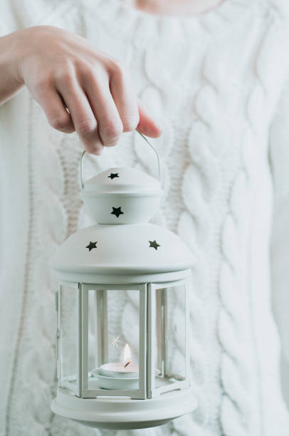 istock A woman in a white sweater holding a Christmas lantern 1068231004