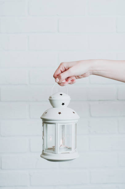 istock Woman holding a Christmas lantern on a white wall background 1068231060