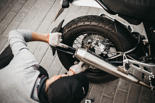 Garage mechanic working on motorcycle in China