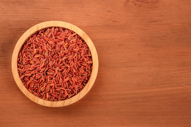 czerwony ryż, nakręcony z góry w drewnianej misce na ciemnym rustykalnym tle z miejscem na tekst - camargue red rice zdjęcia i obrazy z banku zdjęć