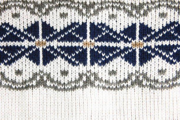 Bright white, brown, blue and grew jacquard knitted pattern of wool sweater. Rustic, wool.