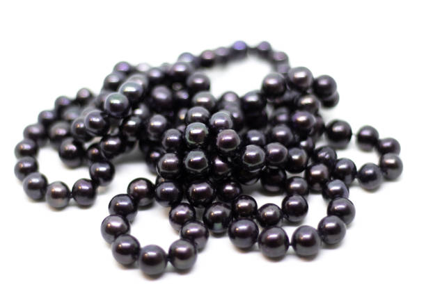 istock Natural cultered black pearl beads string on a white background 1068256498