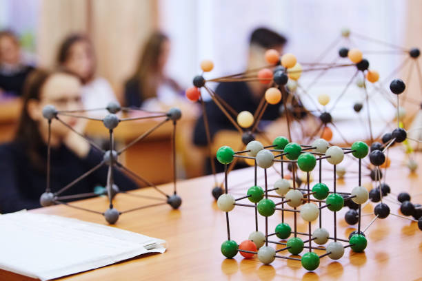 istock Students sit in the classroom and listen to a lecture in science. Plastic molecular educational model. Soft focus background image 1068259358