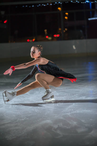 istock Ice skater is squating down on the ice 1068267926