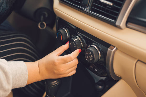 istock Hand of woman turning on car air conditioning system,Button on dashboard in car panel 1068268882