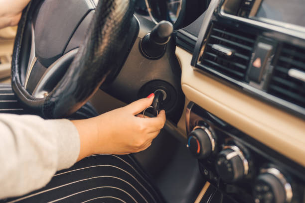 istock Woman hand put key into the ignition and starts the car engine 1068270300