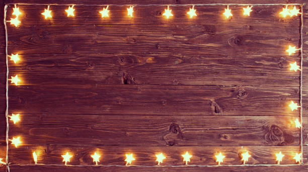 istock Merry Christmas! Christmas lights frame on wooden background with copy space 1068276446