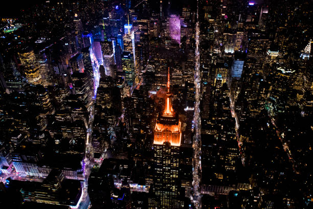 Empire State Building in New York at night Aerial view of the Empire State Building taken from a helicopter above New York at night time. broadway manhattan stock pictures, royalty-free photos & images