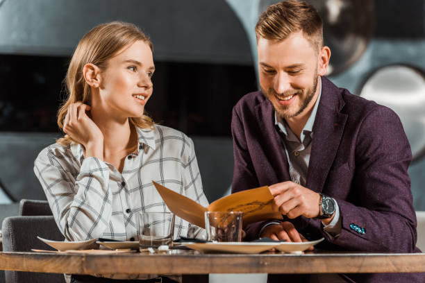 istock Happy smiling couple looking in menu to order dinner in restaurant 1068293408