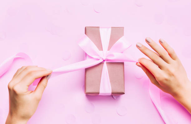 istock Beautiful woman hands with beautiful manicure open gift box. 1068303506