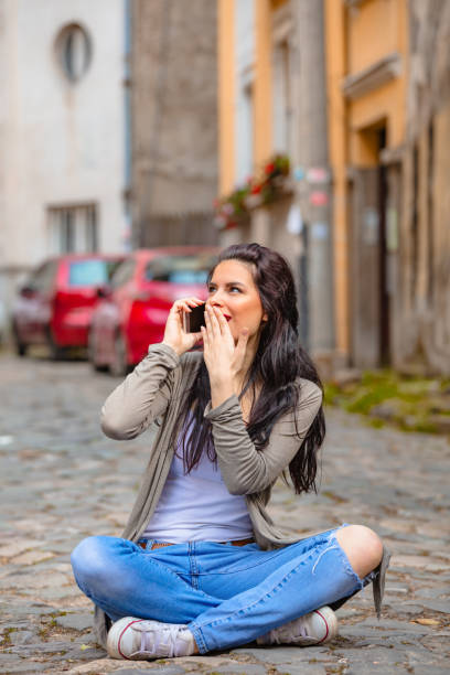 Cute young woman using cellphone in urban surroundings.