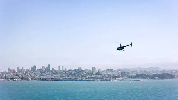 Photo of Aerial view of helicopter flying in the San Francisco Bay overlooking the city on a sunny day