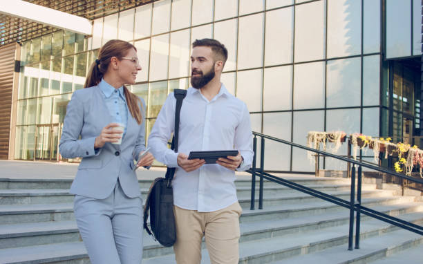 istock Two business people browsing on tablet computer outdoors 1068313190