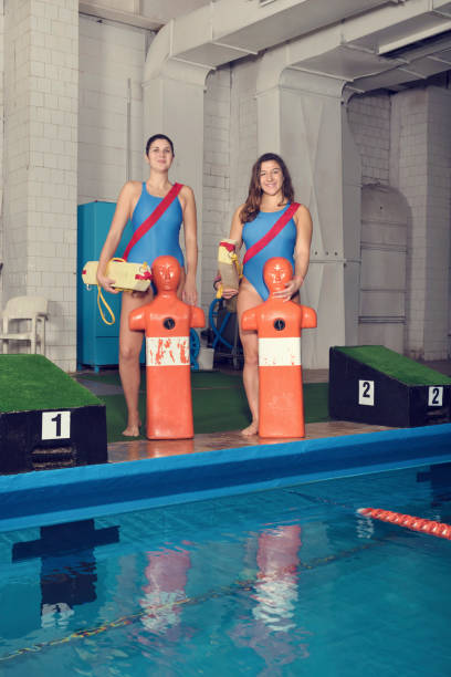 two trainers with training dummy at a pool - lifeguard association imagens e fotografias de stock