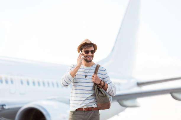 istock Handsome young guy in front of an airplane 1068313304
