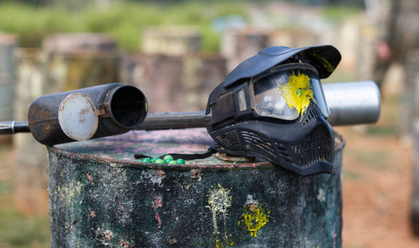 Paintball mask with splash Closeup of black paintball mask with splash after direct hit from marker gun after match outdoors paintballing stock pictures, royalty-free photos & images