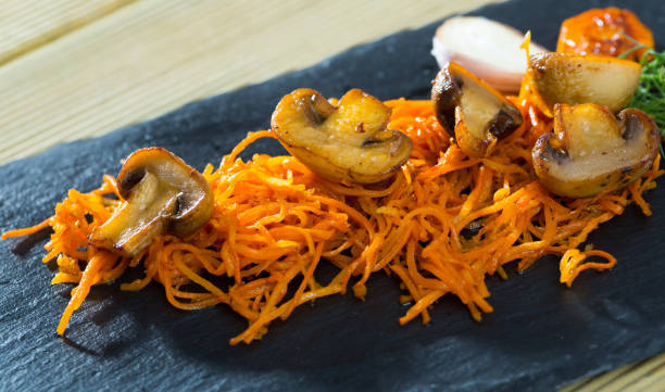 istock Slate of freshly fried mushrooms with carrot 1068322434