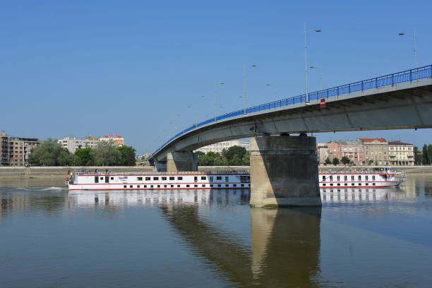 Tourist ship passing under the bridge on river Danube, Novi Sad, Serbia Novi Sad, Serbia - May 27th 2018.- Tourist ship passing under the bridge on river Danube, Novi Sad, Serbia danube river stock pictures, royalty-free photos & images