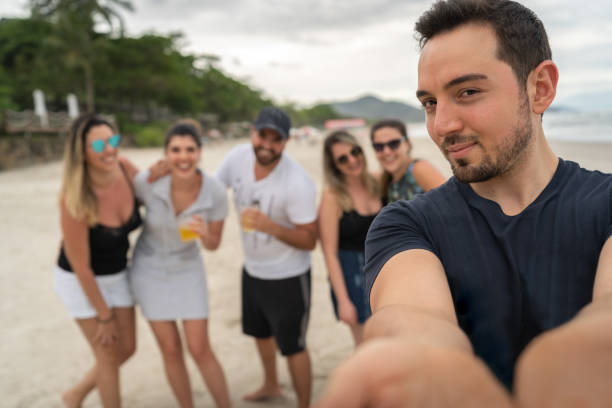 groupe d’amis prenant un selfie à la plage - natural phenomenon affectionate looking at camera outdoors photos et images de collection