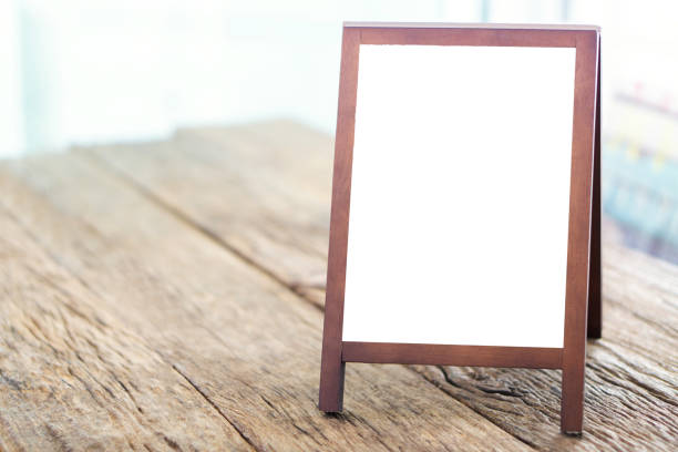 istock Mock up blank advertising whiteboard with easel standing on wood table in cafe and bar restaurant for display or montage of design space for text 1068343044