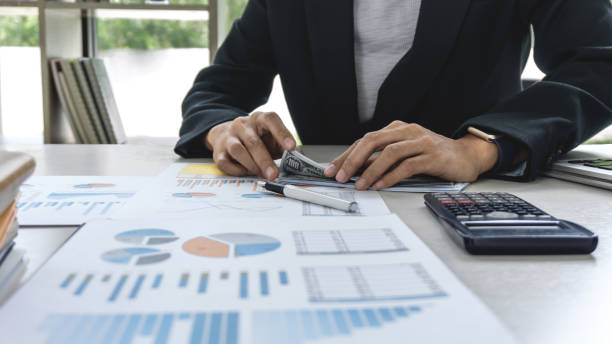 istock Business woman accountant working and calculating financial data on graph documents, doing finance in workstation 1068343110