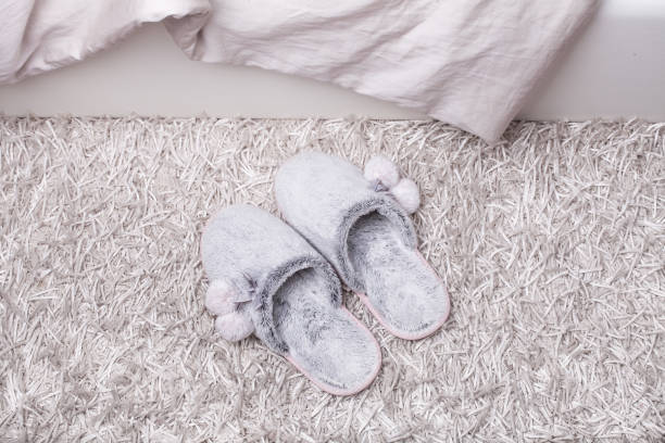 istock fur slippers on a fluffy carpet near the bed 1068349716
