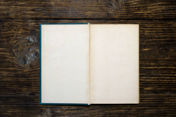 istock Old open book on wooden background. 1068349774