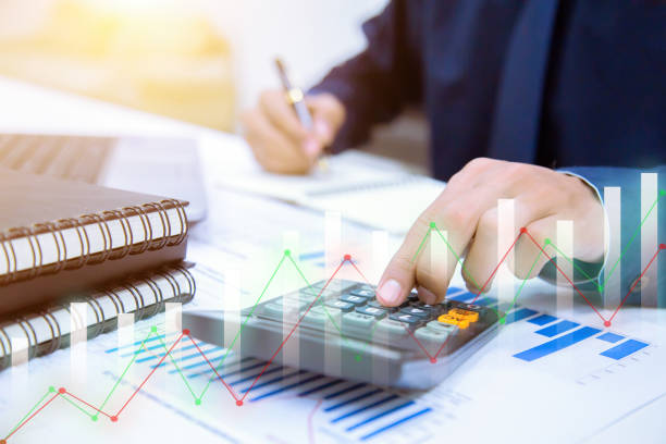 istock Businessman hands using calculator and Financial data analyzing at the office. 1068359360