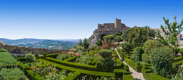 An idyllic view of the Rocca Flea Castle of Gualdo Tadino, a medieval town between Spoleto and Gubbio, in the Italian region of Umbria. The Rocca Flea is a fortified building built in the 12th century by Emperor Frederick II of Swabia in 1242. Perfectly preserved, it is currently owned by the Municipality of Gualdo Tadino and inside it is possible to admire an antiquarium and the historic ceramics of Gualdo. An important city since Roman times, Gualdo Tadino rises along the ancient consular Via Salaria, traced by the Romans. Its history runs throughout the Middle Ages and, despite having been partially destroyed and sacked numerous times and placed under the dominion of Perugia, this ancient Umbrian center still retains its medieval charm. The Umbria region, considered the green lung of Italy for its wooded mountains, is characterized by a perfect integration between nature and the presence of man, in a context of environmental sustainability and healthy life. In addition to its immense artistic and historical heritage, Umbria is famous for its food and wine production and for the quality of the olive oil produced in these lands. Super wide angle image in high definition format.